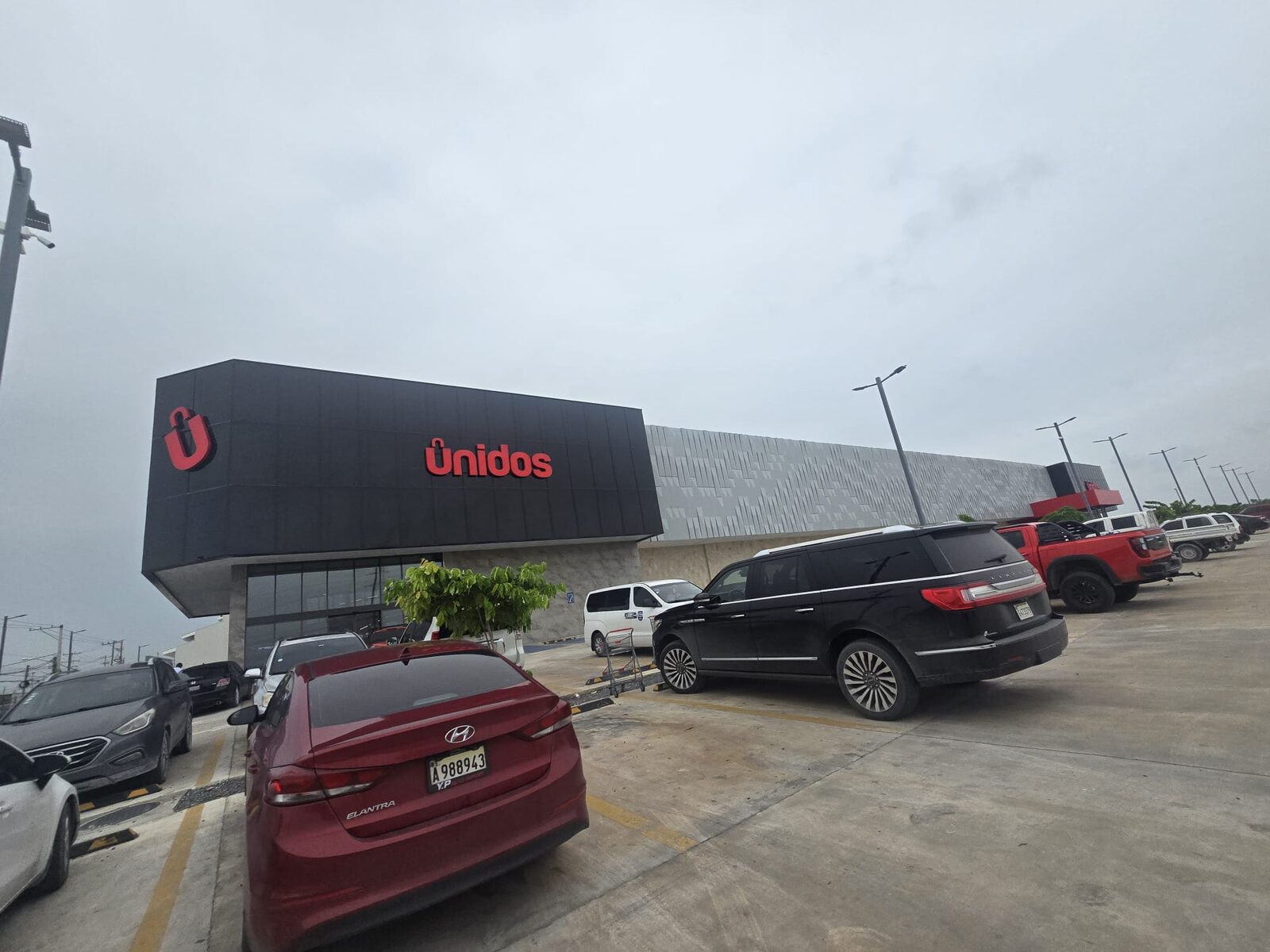 Modern shopping centre exterior with large parking area in Punta Cana