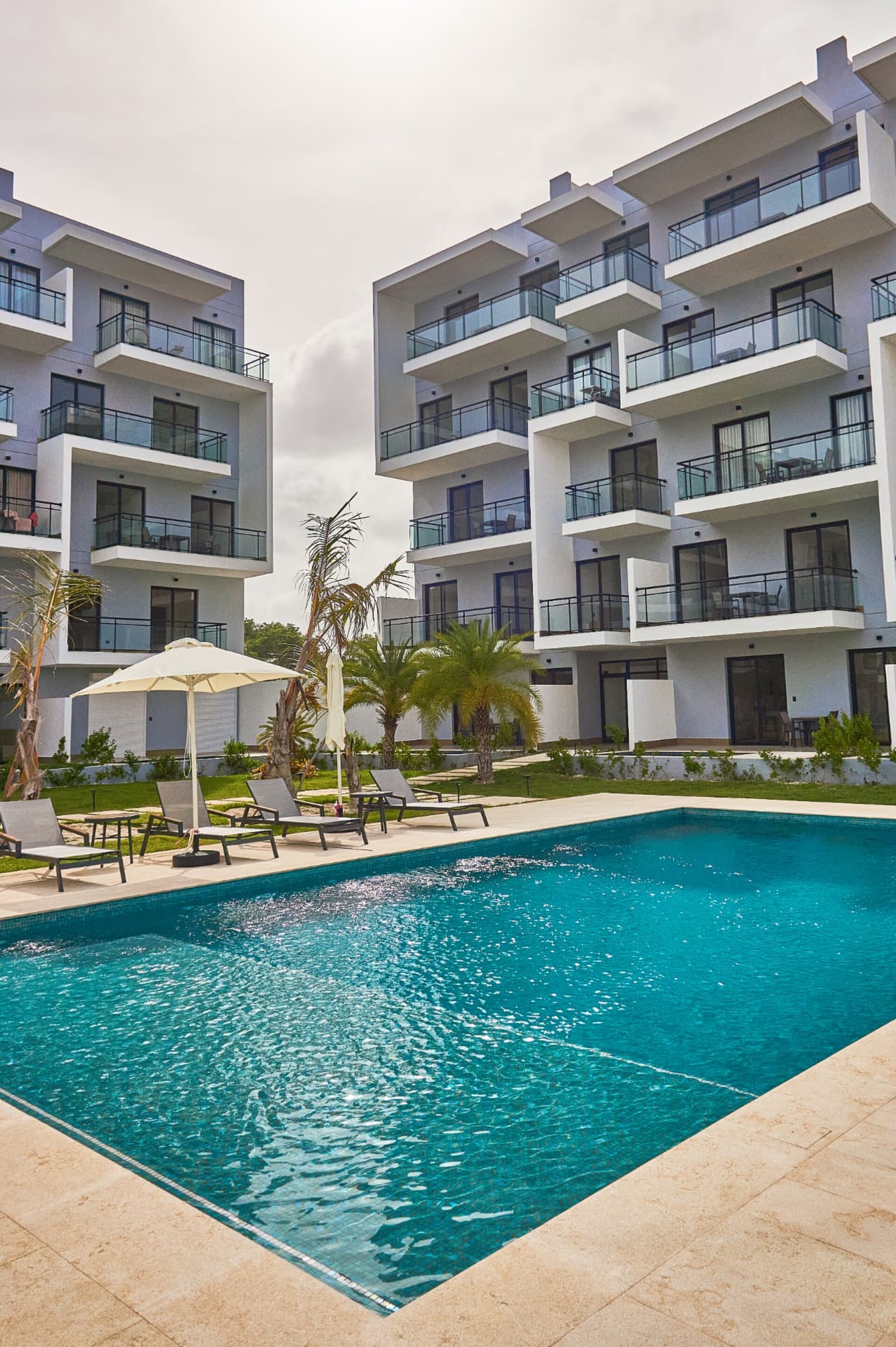 Residence swimming pool with sun loungers and modern apartment buildings