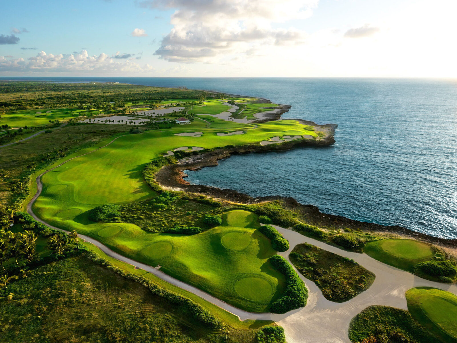 Aerial view of an oceanfront golf course in Punta Cana with fairways along the cliffs